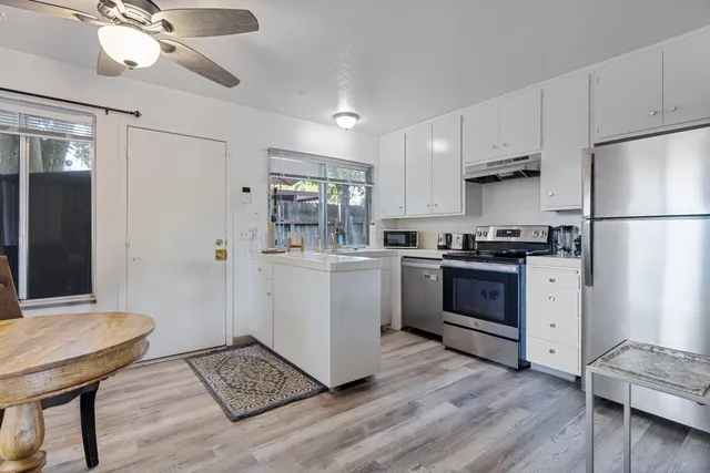 a kitchen with white cabinets and white appliances