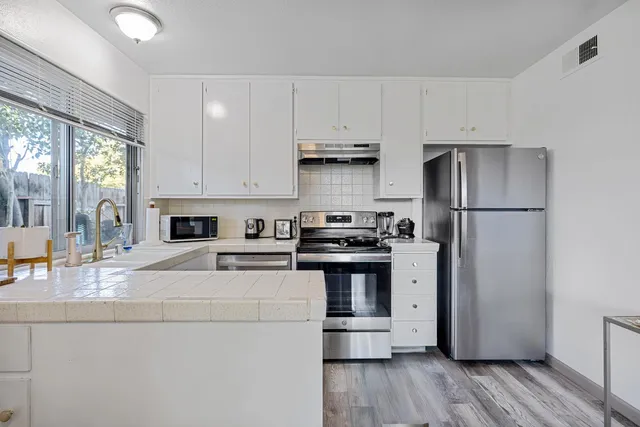 a kitchen with stainless steel appliances a refrigerator sink and stove