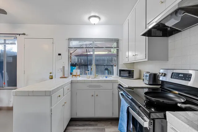 a kitchen with a sink stove and cabinets