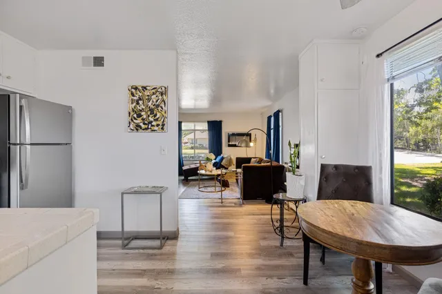 a living room with furniture a table and wooden floor