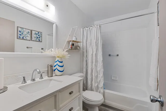 a bathroom with a sink a toilet and a shower