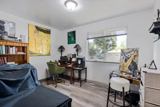 a view of a workspace with furniture and a window