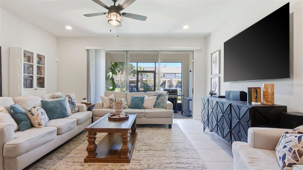 3013 Alessa Loop Apopka, FL 32703 - Photo 11 of 31 a living room with furniture a flat screen tv and a large window