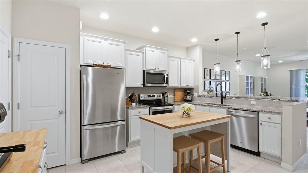 3013 Alessa Loop Apopka, FL 32703 - Photo 6 of 31 a kitchen with stainless steel appliances granite countertop a refrigerator a sink a stove a microwave and a refrigerator