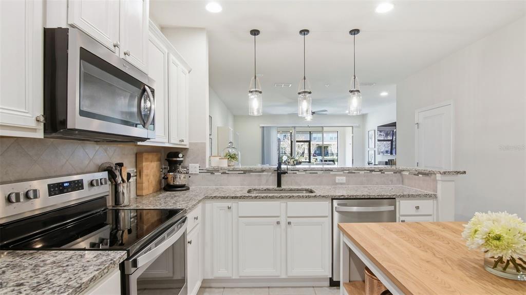 3013 Alessa Loop Apopka, FL 32703 - Photo 8 of 31 a kitchen with stainless steel appliances granite countertop a stove a sink and a microwave