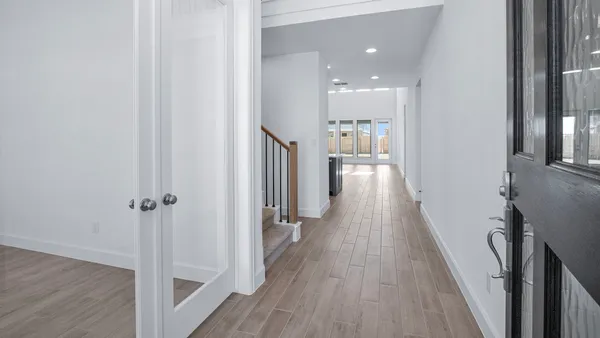 a view of a hallway with wooden floor and staircase