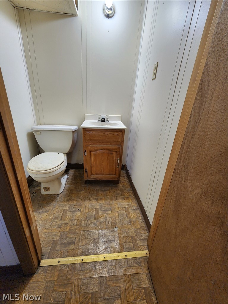 13500 Rugby Road Cleveland, OH 44110 - Photo 11 of 18 Bathroom with toilet, vanity, and parquet flooring
