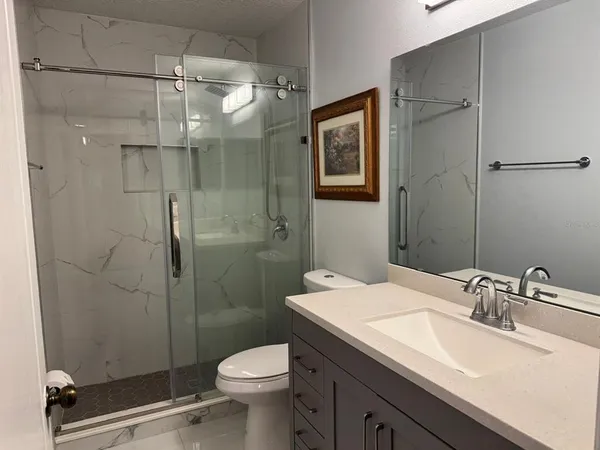a bathroom with a sink toilet and shower