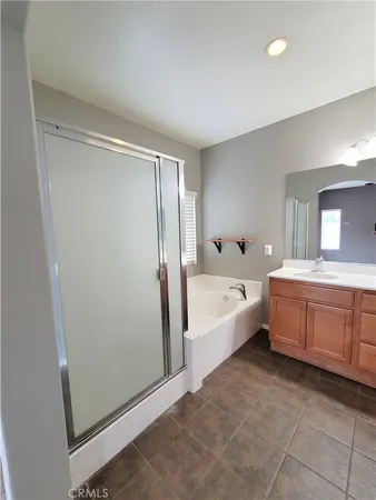 a large spacious bathroom with a tub shower and mirror