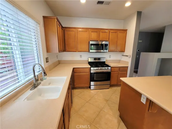 a kitchen with stainless steel appliances a stove a sink a microwave and a refrigerator