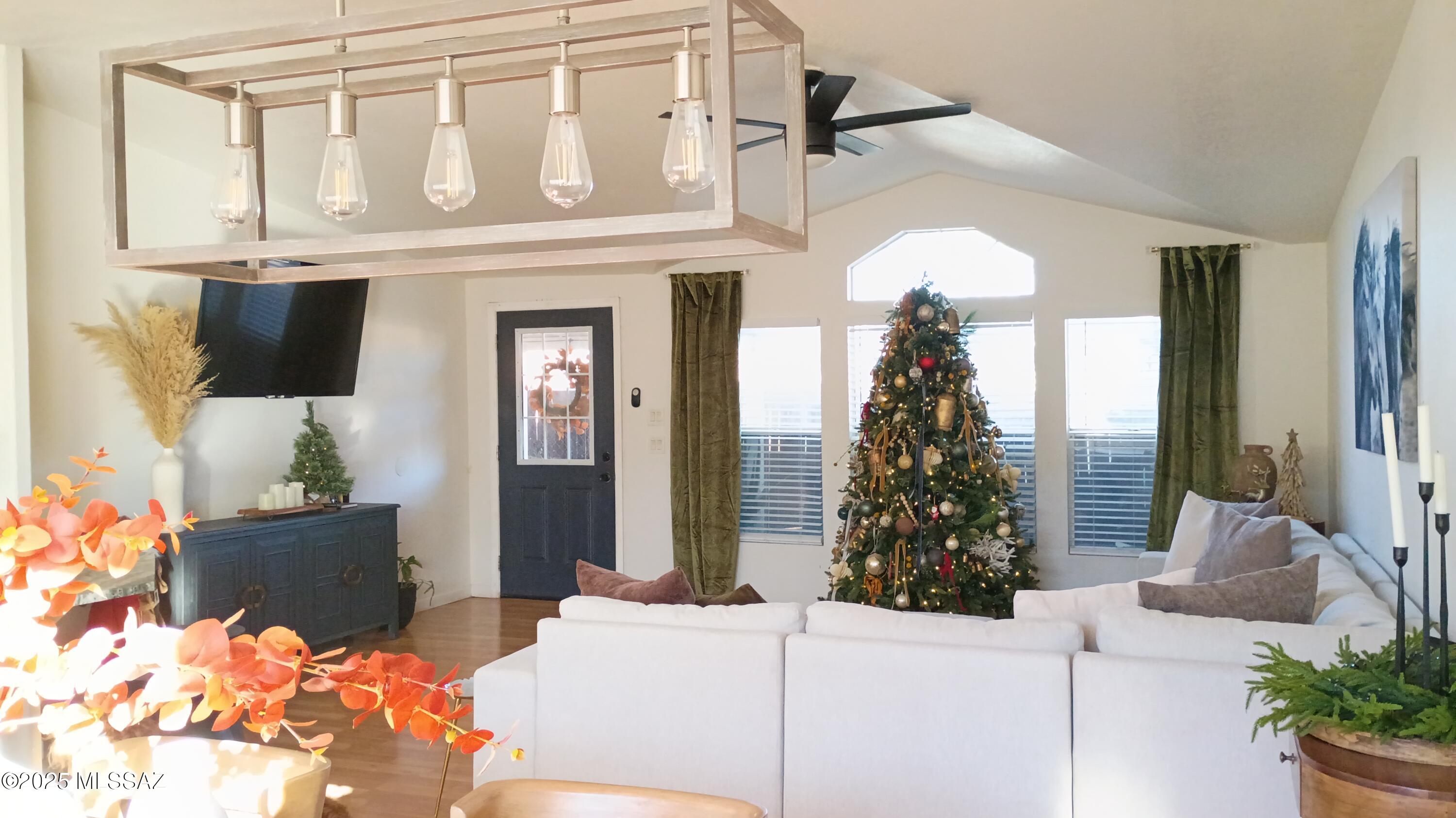 1449 West Hualpai Road Tucson, AZ 85745 - Photo 12 of 49 a living room with furniture a chandelier and a flat screen tv