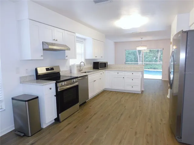 a kitchen with a sink a stove and cabinets