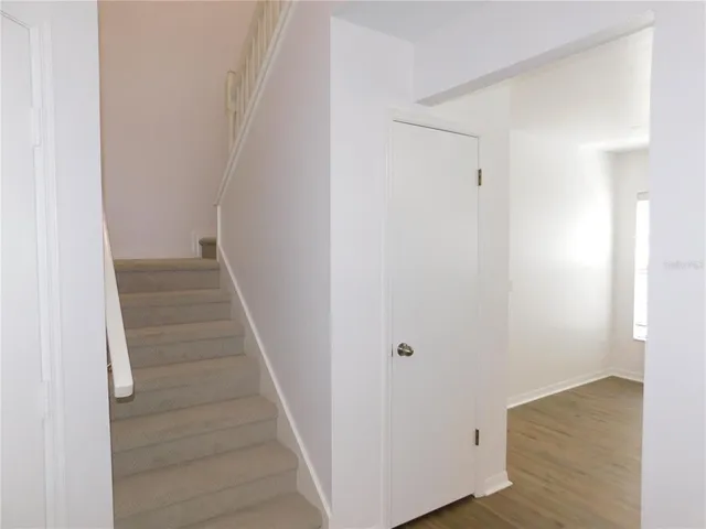 a view of a hallway with wooden floor and entryway