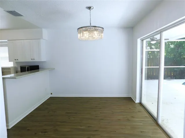 a view of a room with wooden floor and a window