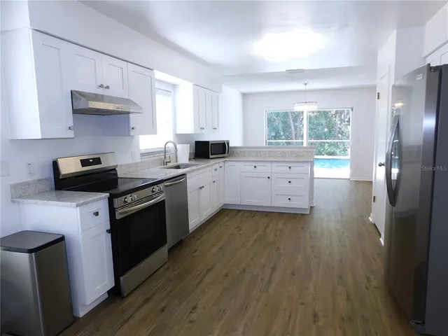a kitchen with a sink stove and cabinets