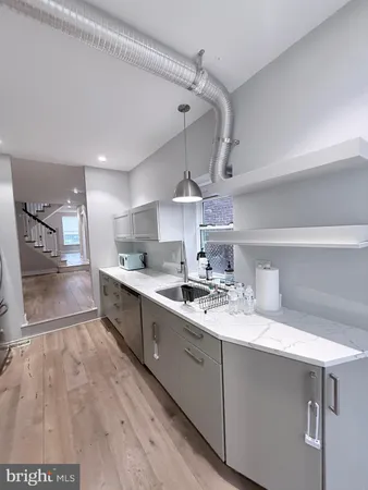 a view of a hallway to room with wooden floor and furniture