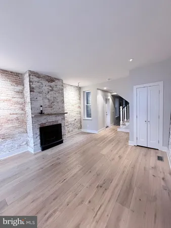 a view of a livingroom with wooden floor and a fireplace