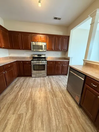 a kitchen with stainless steel appliances granite countertop a stove a sink and a microwave