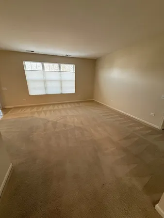 an empty room with windows and ceiling fan