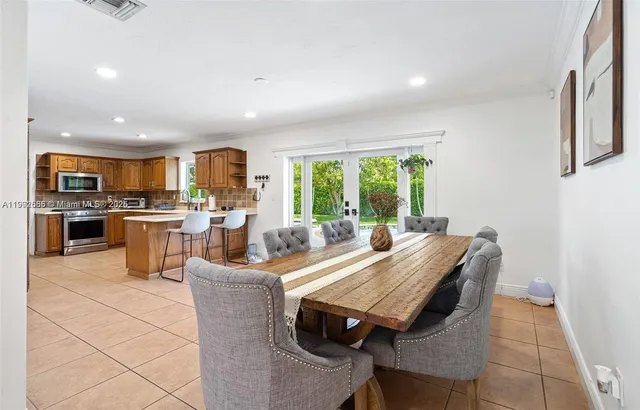a view of a dining room with furniture a chandelier and kitchen view