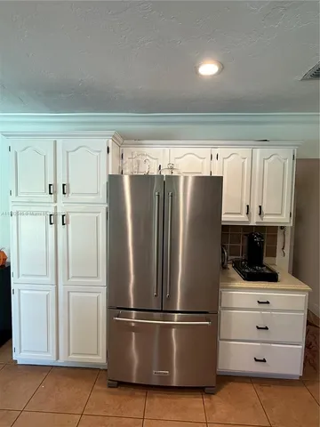 a kitchen with refrigerator a microwave and cabinets