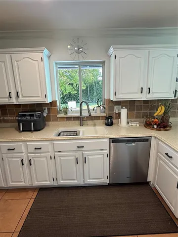 a kitchen with stainless steel appliances granite countertop a stove a sink and white cabinets