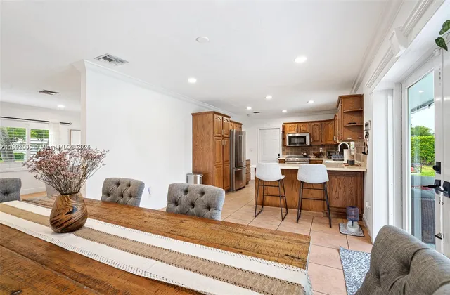 a living room with furniture kitchen view and a large window