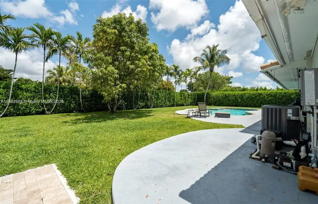a view of a swimming pool with a garden and trees