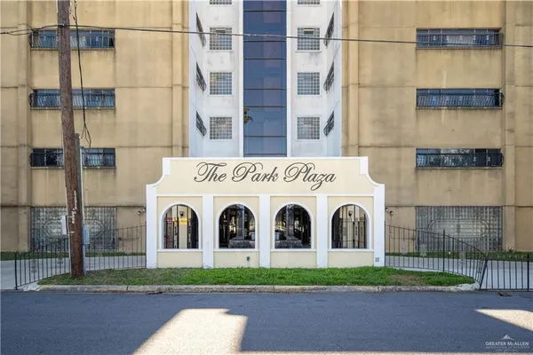 a view of a white building with a yard