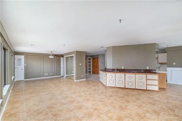 a view of an empty room with kitchen