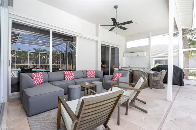 a living room with furniture a ceiling fan and a large window