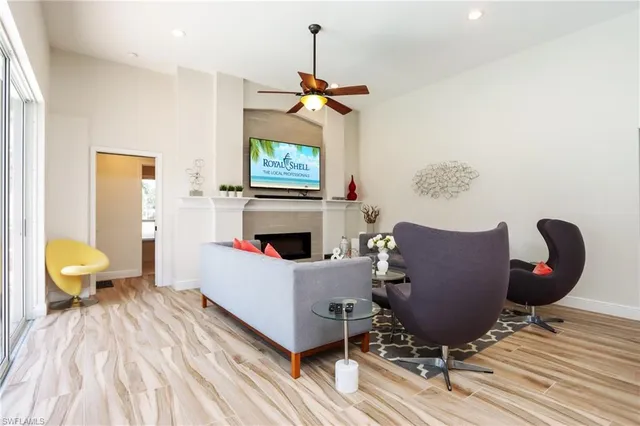 a living room with furniture a fireplace and a chandelier
