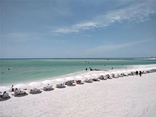 a roof deck with table and chairs under an umbrella with a barbeque