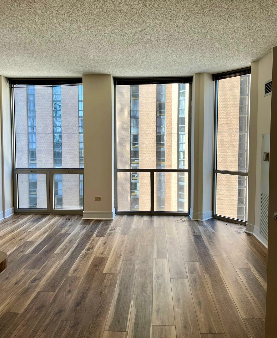 222 North Columbus Drive, Unit 806 Chicago, IL 60601 - Photo 5 of 16 a view of a room with wooden floor and a window