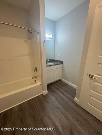 a bathroom with a tub shower vanity and a sink