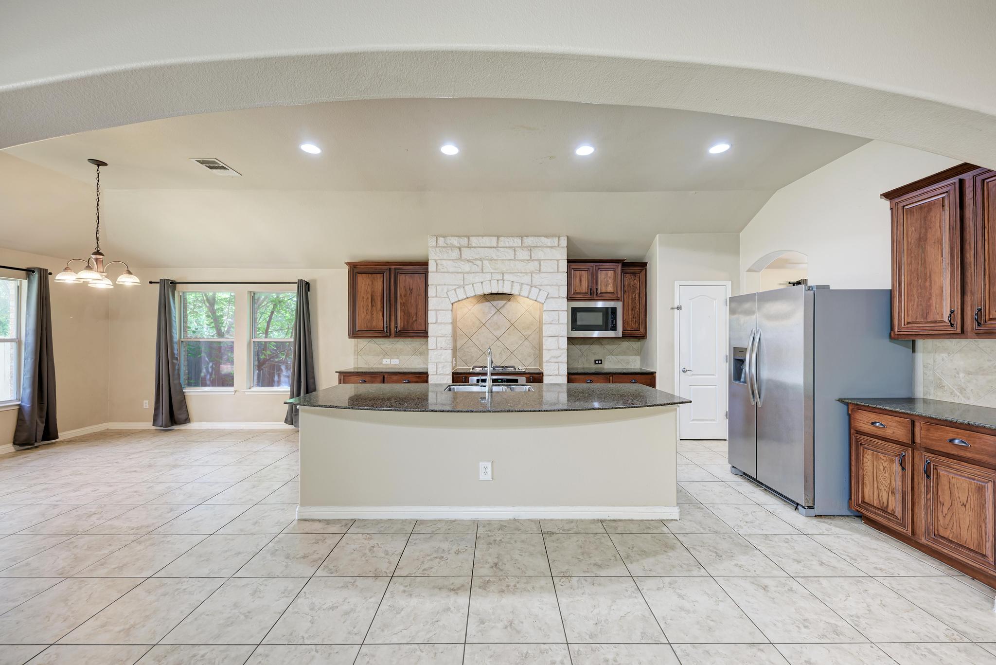 18308 Shallow Pool Drive Pflugerville, TX 78660 - Photo 11 of 40 The large kitchen island provides seating and views to the living room and breakfast nook.