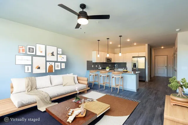 a living room with furniture and kitchen view