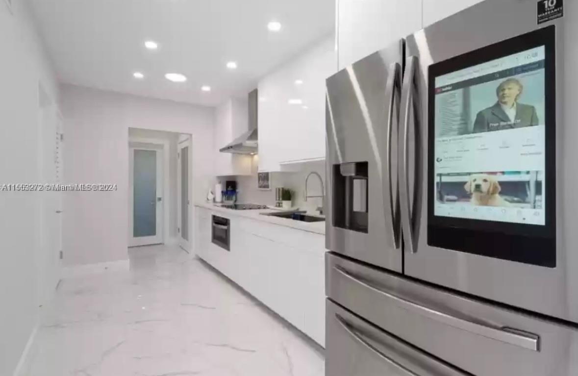 3172 Southwest 2nd Street, Unit 3172 Miami, FL 33135 - Photo 13 of 15 a kitchen with stainless steel appliances a refrigerator sink and white cabinets