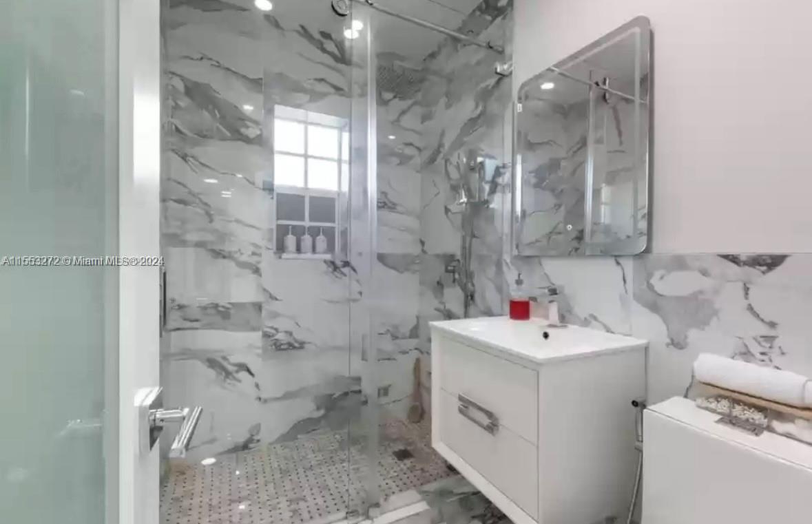 3172 Southwest 2nd Street, Unit 3172 Miami, FL 33135 - Photo 9 of 15 a bathroom with a sink mirror and shower