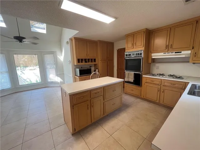a kitchen with a sink a stove a refrigerator and cabinets