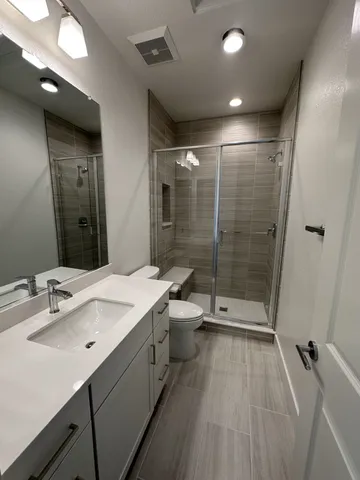 a bathroom with a sink shower and a mirror