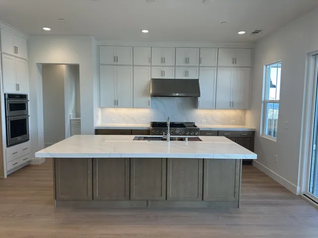 a kitchen with kitchen island a sink stove and refrigerator