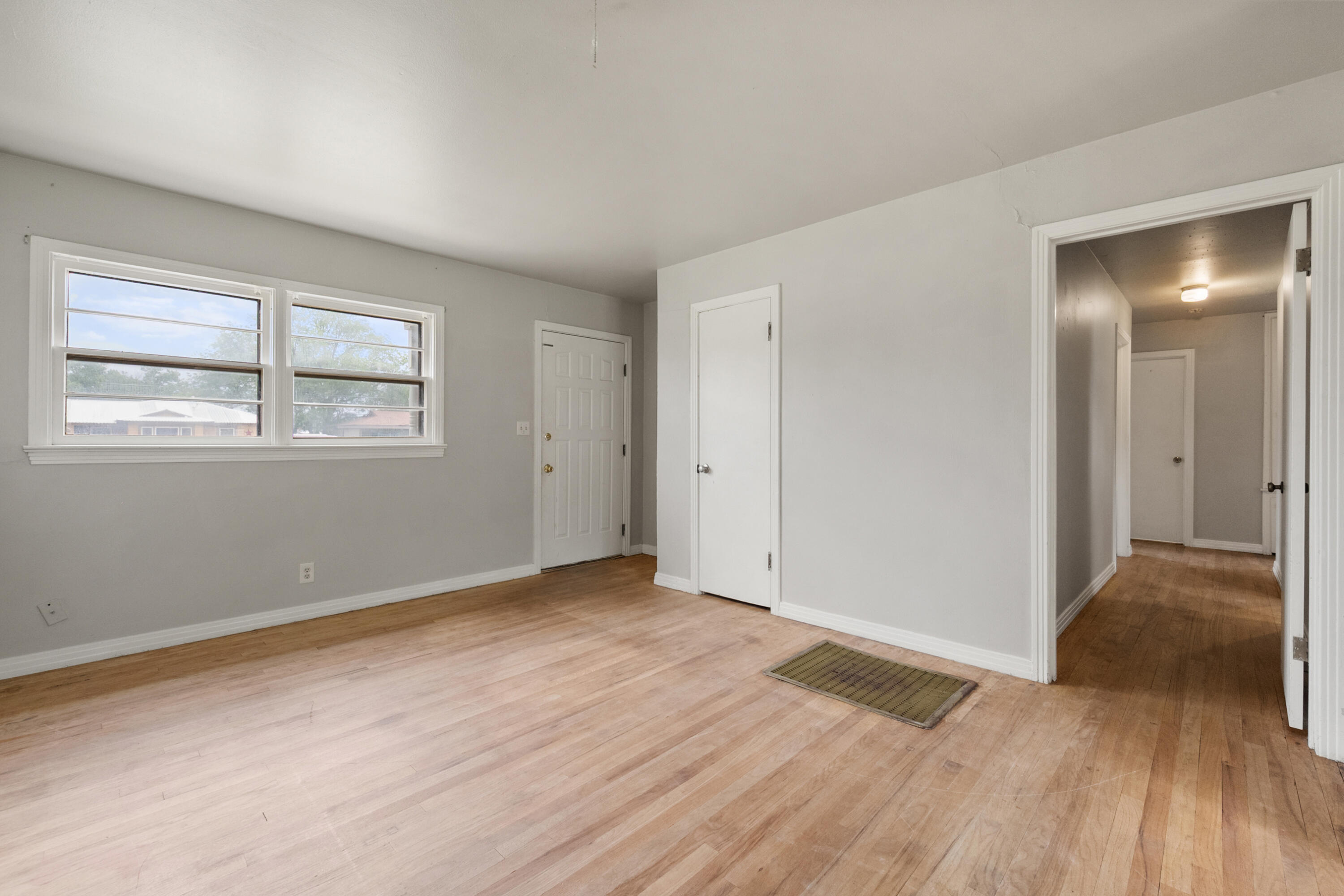 811 Zephyr Plainview, TX 79072 - Photo 7 of 25 a view of an empty room with wooden floor and a window