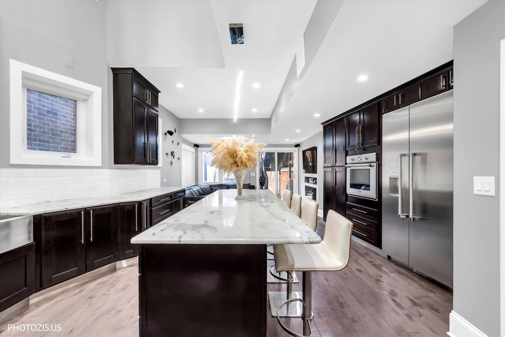 461 West Melrose Street Chicago, IL 60657 - Photo 19 of 83 a kitchen with stainless steel appliances kitchen island granite countertop a table chairs and a refrigerator
