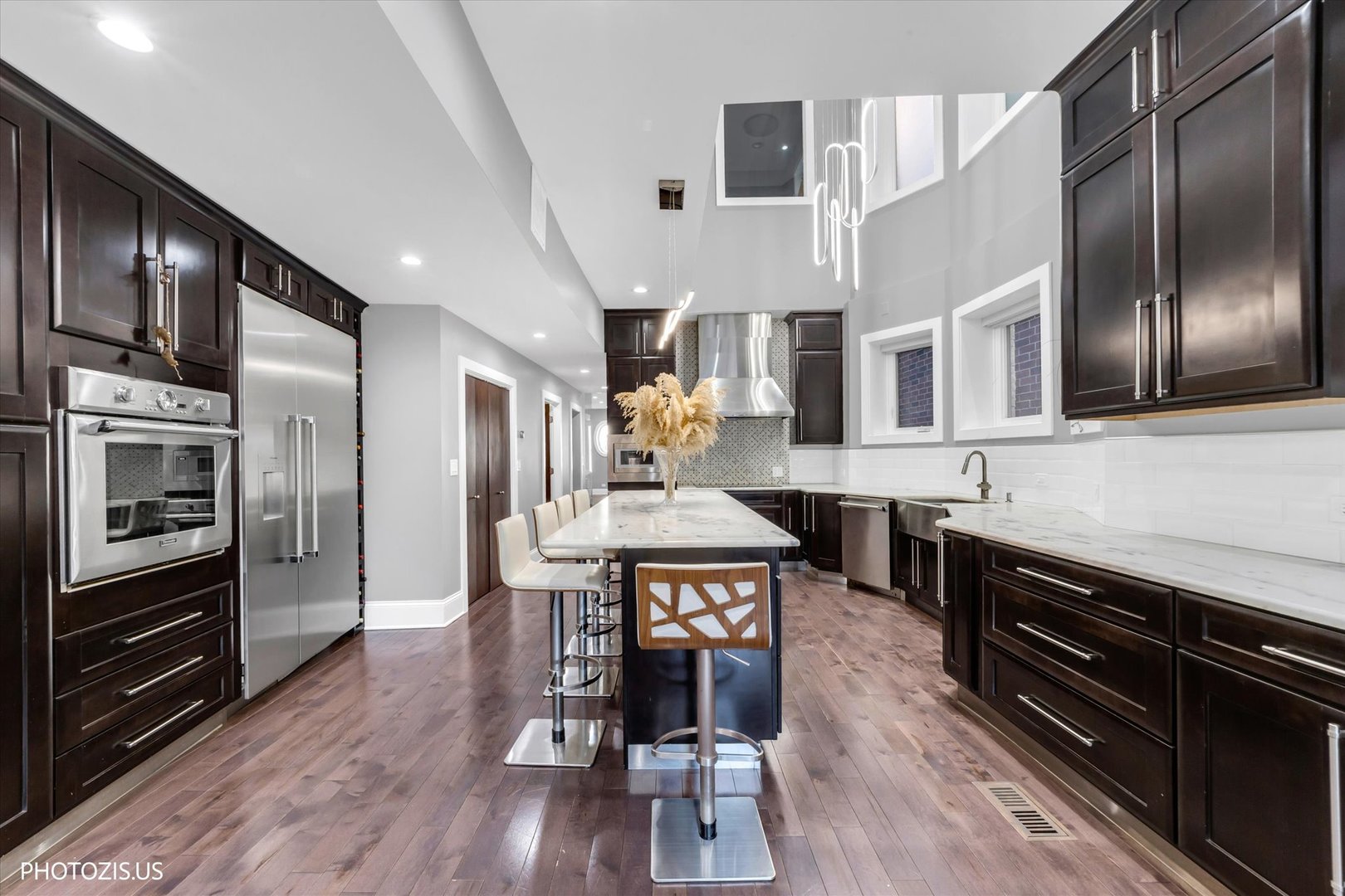 461 West Melrose Street Chicago, IL 60657 - Photo 23 of 83 a kitchen with stainless steel appliances granite countertop a refrigerator a stove a sink dishwasher a dining table and chairs with wooden floor