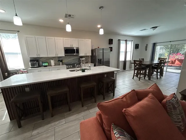a living room with furniture a dining table and kitchen view