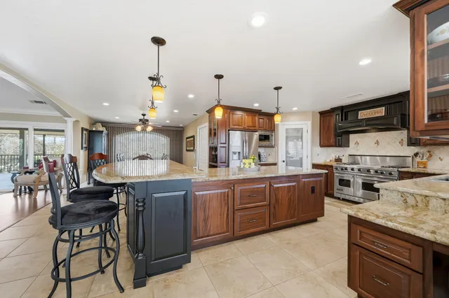 a kitchen with stainless steel appliances granite countertop wooden cabinets stove top oven and sink