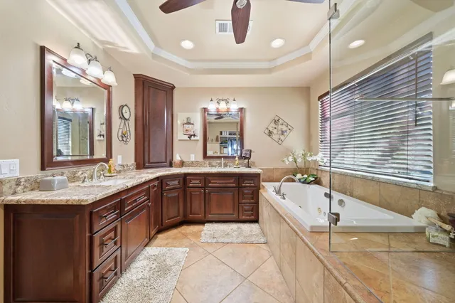 a bathroom with a granite countertop double vanity sink and a mirror