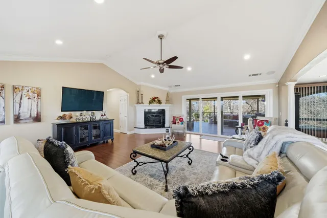 a living room with furniture a flat screen tv and a large window