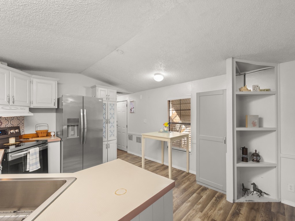 7380 129th Street Sebastian, FL 32958 - Photo 21 of 36 a kitchen with stainless steel appliances kitchen island a refrigerator sink and cabinets